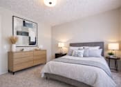 Thumbnail 4 of 14 - A bedroom with a large bed and a wooden dresser.