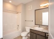 Thumbnail 13 of 13 - A white toilet sits in a bathroom next to a sink and a mirror.