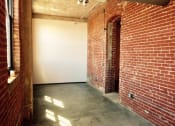 Thumbnail 18 of 34 - an empty room with a brick wall and a door
