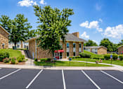 Thumbnail 16 of 18 - A parking lot in front of a building with a red awning.