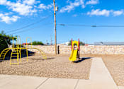Thumbnail 6 of 6 - A playground with a yellow slide and red swings.
