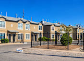 Thumbnail 2 of 6 - A row of houses with black fences in front.