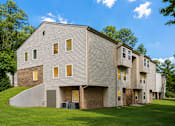 Thumbnail 2 of 4 - A modern building with a grey facade and multiple windows.