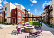 Thumbnail 1 of 25 - A courtyard with a fire pit and chairs.