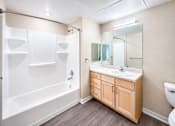 Thumbnail 20 of 25 - A bathroom with a white tub, sink, and toilet.