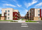 Thumbnail 4 of 25 - A street view of a residential area with apartment buildings on both sides.