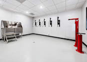 Thumbnail 24 of 25 - A room with a red object on the right and a metal table on the left.