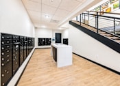 Thumbnail 8 of 25 - A room with a white table and black lockers.