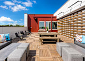 Thumbnail 5 of 25 - A wooden deck with a bench and chairs.
