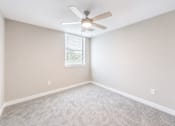 Thumbnail 22 of 25 - A room with a ceiling fan and carpeted floor.