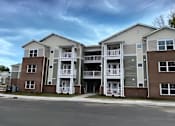 Thumbnail 1 of 6 - Apartment complex with multiple buildings and balconies.