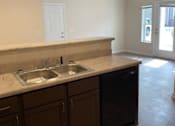 Thumbnail 6 of 6 - A kitchen with brown cabinets and a marble countertop.