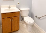 Thumbnail 8 of 12 - A white toilet sits next to a sink in a bathroom.