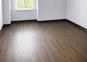 Thumbnail 11 of 12 - A room with a window and wooden flooring.