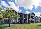 Thumbnail 1 of 23 - A blue building with a tree in front of it.