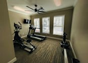 Thumbnail 3 of 9 - a home gym with exercise machines and a ceiling fan