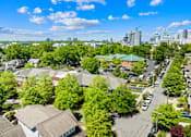 Thumbnail 10 of 13 - A suburban area with houses and trees in the foreground and a city skyline in the background.