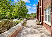 Thumbnail 3 of 13 - A brick building with a walkway in front of it.