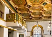 Thumbnail 12 of 16 - A grand staircase with a golden railing leads to a doorway.