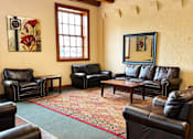 Thumbnail 11 of 16 - A living room with leather couches and a rug.