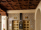 Thumbnail 13 of 16 - A room with a wooden ceiling and a wall with a patterned tile design.