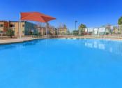 Thumbnail 9 of 9 - a large swimming pool with an umbrella in front of a building