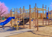 Thumbnail 4 of 9 - a playground with a blue slide and other playground equipment
