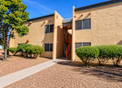 Thumbnail 5 of 14 - A building with a brown facade and a clear blue sky in the background.