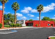 Thumbnail 9 of 14 - A red building with palm trees in front of it.