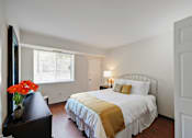 Thumbnail 4 of 15 - A bedroom with a bed, nightstand, and window.