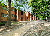 Thumbnail 1 of 15 - A brick building with a tree in front of it.