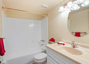 Thumbnail 13 of 15 - A white bathroom with a toilet, sink, and mirror.