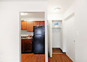 Thumbnail 9 of 15 - A black refrigerator in a kitchen with wooden cabinets.