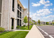 Thumbnail 9 of 22 - A sunny day at a residential complex with a clear blue sky.
