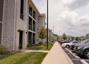 Thumbnail 9 of 22 - A row of cars parked in a parking lot in front of a building.