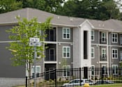 Thumbnail 12 of 22 - Apartment building with a sign that says "Clover Trail" and "Minute Mile".