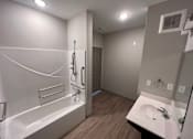 Thumbnail 19 of 22 - A bathroom with a white tub and sink.