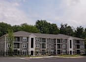 Thumbnail 6 of 22 - A large apartment complex with a black fence in front.