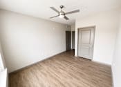 Thumbnail 17 of 22 - A room with a ceiling fan and wooden flooring.