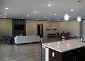 Thumbnail 8 of 22 - A modern living room with a white sofa and a television.