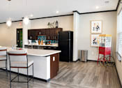 Thumbnail 5 of 22 - A kitchen with a black refrigerator and a white countertop.