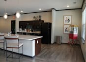 Thumbnail 5 of 22 - A kitchen with a white counter and a black fridge.