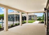 Thumbnail 2 of 22 - A covered walkway leads to a pool and houses.