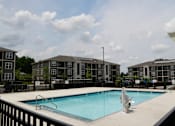 Thumbnail 3 of 22 - A swimming pool in front of apartment buildings.