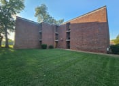 Thumbnail 2 of 7 - the side of a brick building with green grass