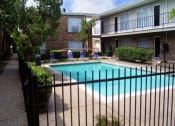 Thumbnail 1 of 7 - a swimming pool in front of an apartment building