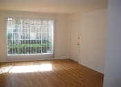 Thumbnail 6 of 7 - an empty living room with a large window and wooden floors
