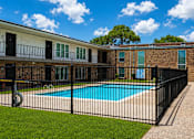 Thumbnail 7 of 10 - A black fence surrounds a small pool in a sunny backyard.