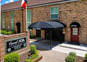 Thumbnail 1 of 10 - A brick building with a sign that says "Coral Hills Apartment".