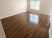 Thumbnail 15 of 23 - A room with wooden floors and a window with blinds.